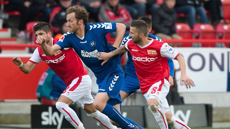 Laufduell: Die Berliner Baris Özbek (l.) und Benjamin Köhler (r.) und Dominic Peitz aus Karlsruhe versuchen an den Ball zu kommen.