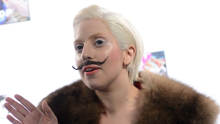 Lady Gaga präsentiert ihr neues Album mit einem angeklebten Schnurrbart.