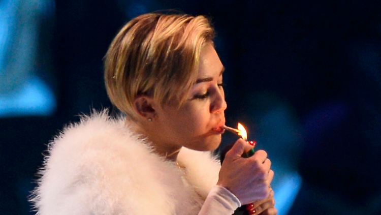 Miley Cyrus steckt sich auf der Bühne eine an.