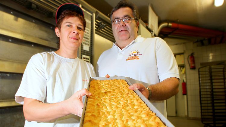 Bäckermeister Tschirch mit seiner Mitarbeiterin und einem Blech Streuselkuchen in seiner Backstube.