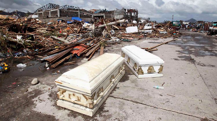 Tod und Verwüstung: In der Stadt Tacloban liegen leere Särge, die vermutlich aus einem Bestattungsunternehmen herausgespült wurden, auf der Straße.