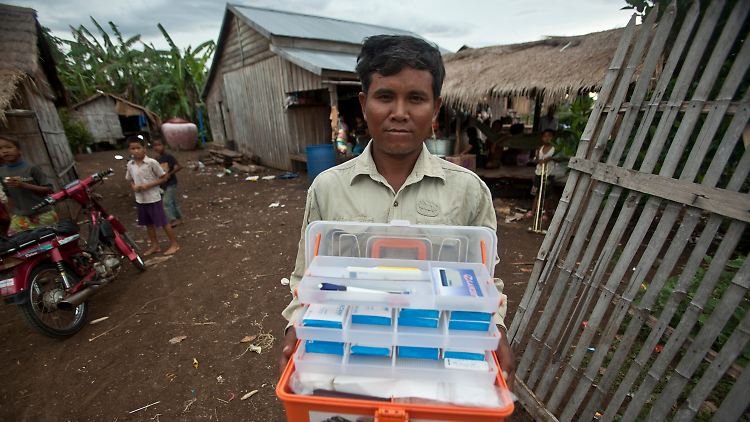 Mitarbeiter der kambodschanischen Gesundheitsbehörde in einem Dorf mit einem Koffer mit Malaria-Medikamenten.