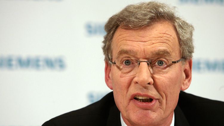 Gerhard Cromme hält an seinem Stuhl fest.