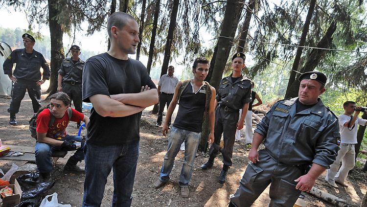 Sergei Udaltsov von einer linken Jugendbewegung unterhält sich im Wald von Chimki mit Polizisten. Der Wald soll abgeholzt werden damit die gebührenpflichtige Autobahn Moskau - St. Petersburg errichtet werden kann.