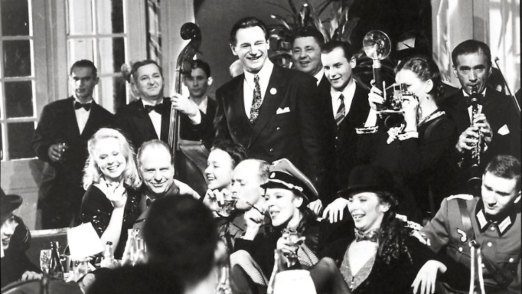 Zu Beginn des Films feiert Schindler (Neeson, M.) rauschende Feste mit Wehrmacht und SS - doch wandelt sich seine Einstellung.