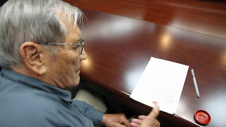 Der US-Veteran Merrill Newman setzt seinen Fingerabdruck unter das angebliche Geständnis.