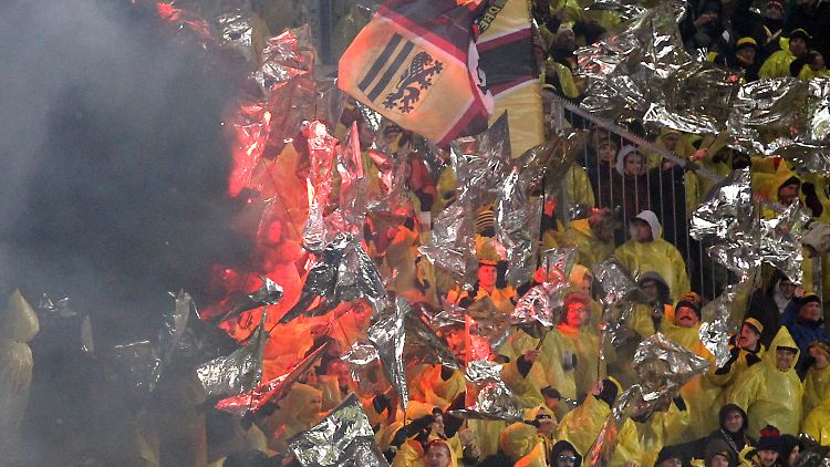 Dresdener Fans stehen im Gästeblock und zünden Pyrotechnik. Vor dem Spiel hatte es massive Ausschreitungen Dresdener Fans in der Stadt gegeben.