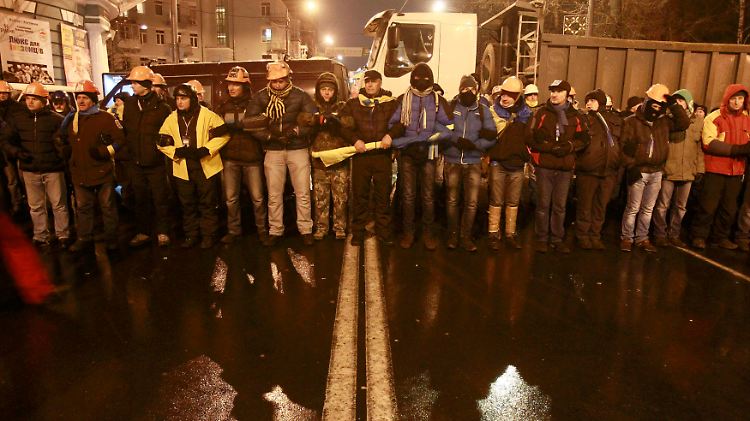 Maskiert und mit Helmen geschützt: Demonstranten rüsten sich für die Proteste in Kiew.