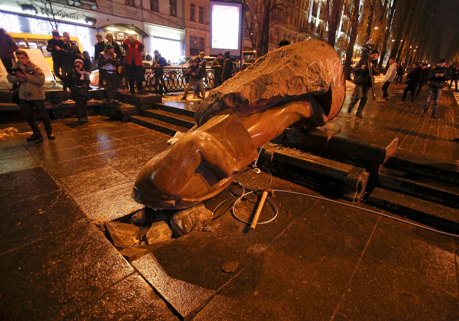 Mit einem Stahlseil reißen Demonstranten am Rande einer Protestaktion die Lenin-Statue von ihrem Sockel.