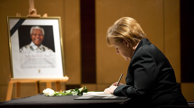 Bundeskanzlerin Merkel trägt sich in der südafrikanischen Botschaft in ein Kondolenzbuch ein.