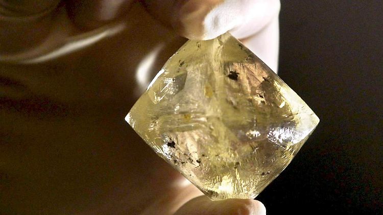 Ein ungeschliffener Rohdiamant - das Muttergestein ist der Kimberlit. Innerhalb dieses Gesteins wandelt sich der Kohlenstoff zu Diamanten um.