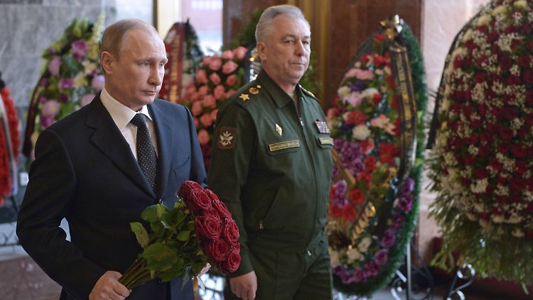 Wladimir Putin erscheint mit roten Rosen zum Begräbnis. 