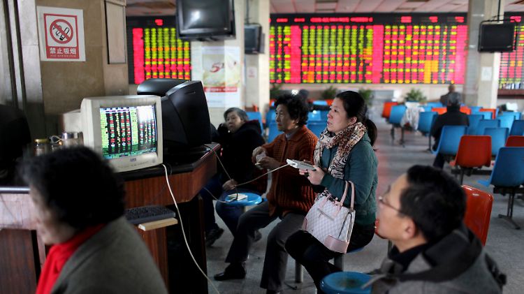 Investoren blicken bei einem Börsenmakler in Shanghai auf Aktienkurse.