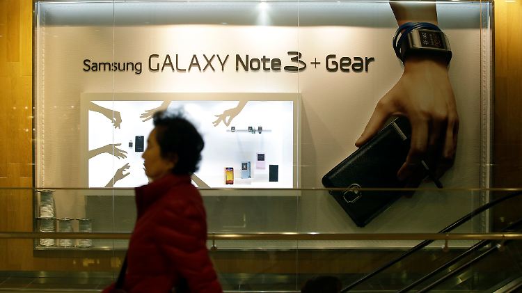 In Seoul geht eine Frau an einer Samsung-Werbung vorbei.