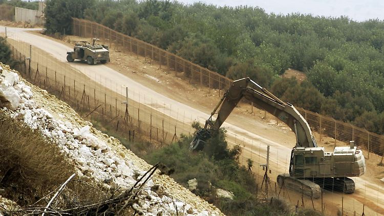 Die Baumfällaktion geht weiter: Nahe des libanesischen Dorfes Adeysseh reißt ein Bulldozer Bäume und Sträucher aus.