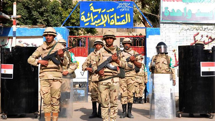 Soldaten stehen vor einer zum Wahllokal umfunktionierten Schule in Port Said. Ab neun Uhr Ortszeit beginnt das Referendum.