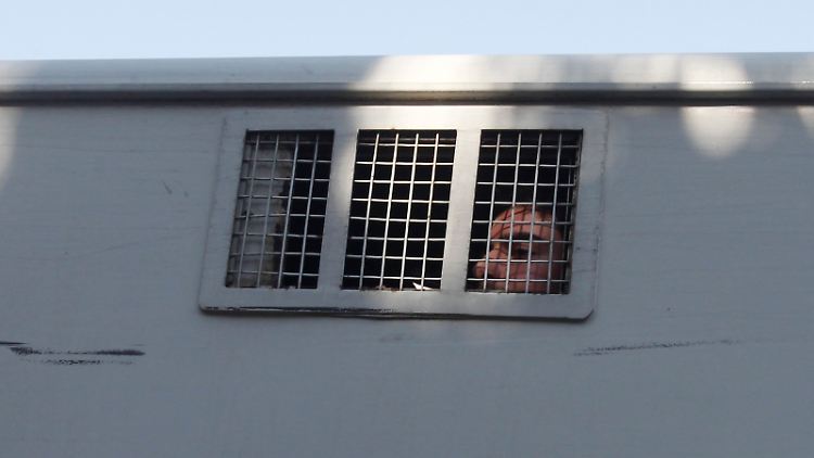 Ein junger Mann wird nach Anti-Regime-Protesten in einem Gefangenentransporter weggebracht. Einem Bericht zufolge hat das Regime systematisch Gefangene umbringen lassen.