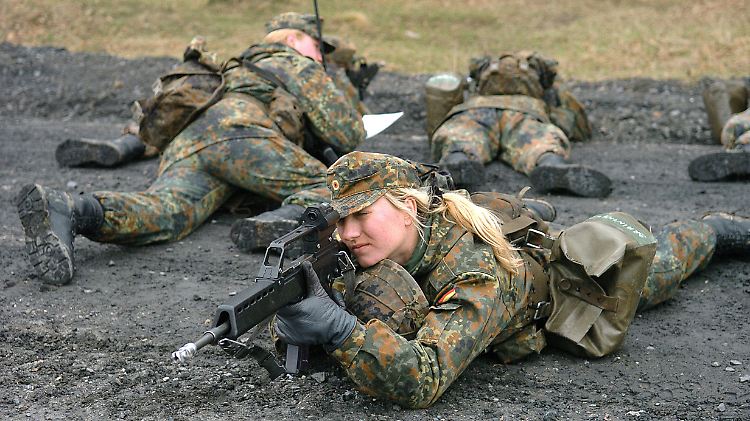 Eine Rekrutin sichert auf einem Truppenübungsplatz eine Patrouille.