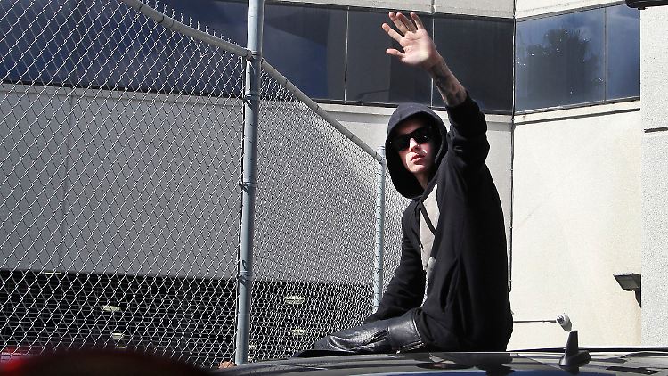 Wie anno dazumal Michael Jackson: Bieber winkt seinen Fans nach der Entlassung vom Dach eines Autos zu.