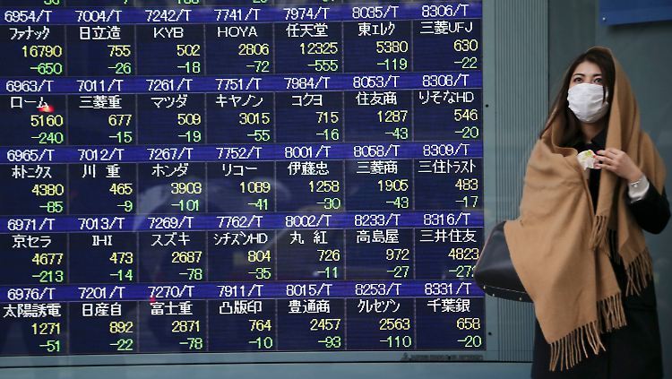 Schmuddelwetter in Tokio: Der Mundschutz soll vor Ansteckungen schützen und zählt in Japan zum gewohnten Straßenbild.