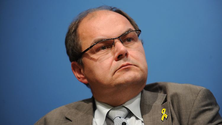 Schmidt folgt auf Friedrich. Die gelbe Schleife am Revers steht für "Solidarität mit unseren Soldaten".