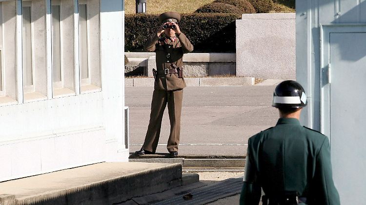 An der innerkoreanischen Grenze beäugen sich ein nordkoreanischer (l.) und ein südkoreanischer Soldat.