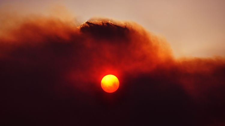 Rauch eines Buschfeuers über Tasmanien: Die Hitzewellen haben laut Klimarat in Adelaide, Melbourne und Canberra jetzt schon den vorhergesagten Stand von 2030 erreicht.