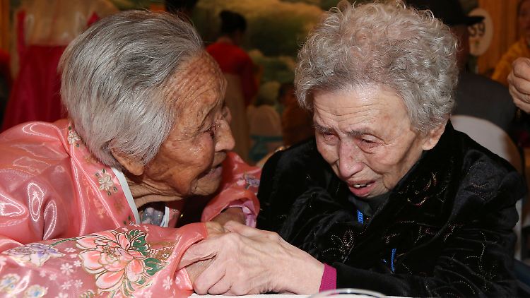 Die 84 Jahre alte Nordkoreanerin Lee Jong Shil (r.) hält die Hand ihrer drei Jahre älteren Schwester. Ihr Leben haben sie getrennt voneinander verbracht.