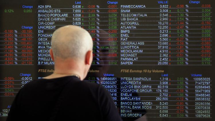 An der Mailander Börse schaut ein Mann auf die Kurstafel.