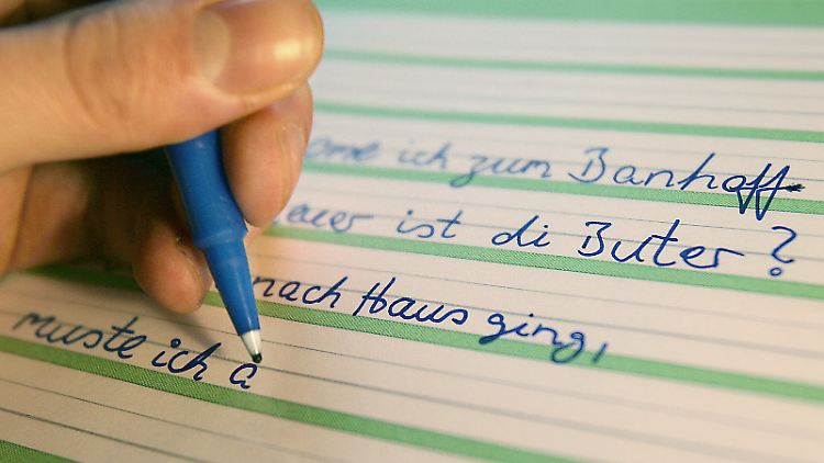 Ein Analphabet schreibt Sätze zur Übung in ein Schulheft.