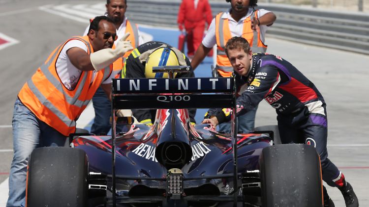 Da hilft nur kräftig anpacken: Sebastian Vettel schiebt seinen Boliden von der Strecke.