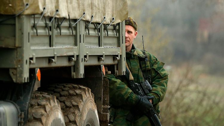 Ein uniformierter Mann, vermutlich ein Russe, steht hinter einem Laster in Sewastopol.