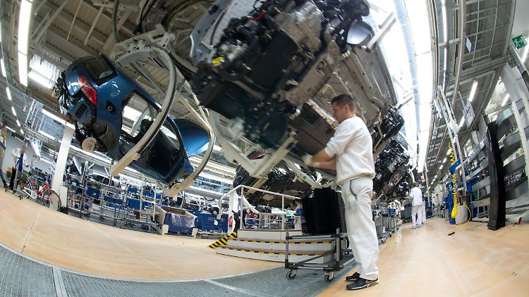 Volkswagen Mitarbeiter arbeiten an der Produktionsstraße für den VW Golf VII.