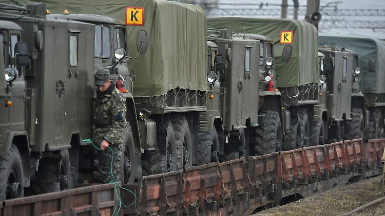 Ukrainische Soldaten verladen Militärfahrzeuge.