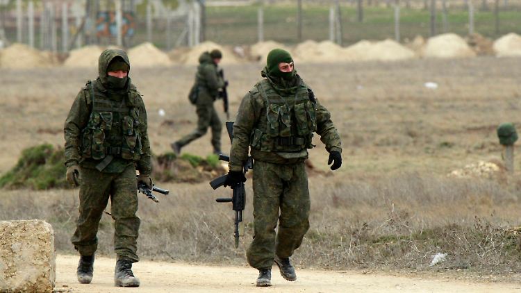 Bewaffnete Männer, bei denen es sich vermutlich um russische Soldaten handeln, patrouillieren auf der Krim.