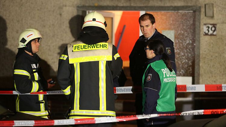 Einsatzkräfte von Polizei und Feuerwehr vor dem Mehrfamilienhaus, in dem das Unglück geschah.