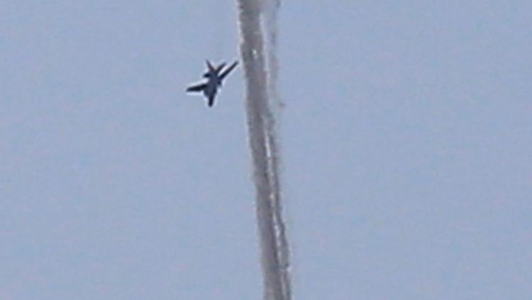 Das abstürzende Flugzeug hinterließ eine dunkle Rauchspur. Daneben ist ein unbekanntes Flugzeug zu sehen.