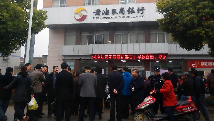 Sparer vor der Rural Commercial Bank of Huanghai in der Stadt Yancheng in der ostchinesischen Provinmz Jiangsu. 