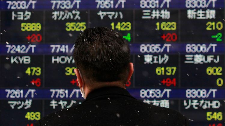 Ein Mann blickt in Tokio auf Aktienkurse. Er kann sich freuen: Der Nikkei klettert den 4. Tag in Folge.