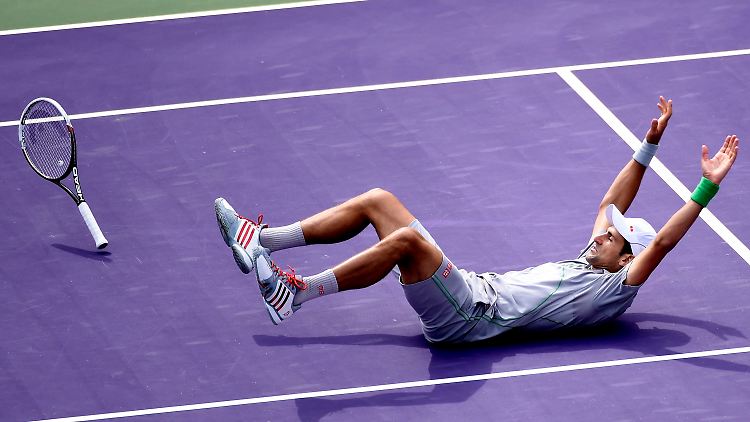 Erleichtert plumpst Novak Djokovic auf den Hosenboden.