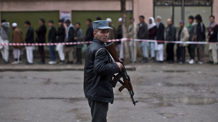 Ein Sicherheitsmann bewacht in Kabul wartende Wähler.