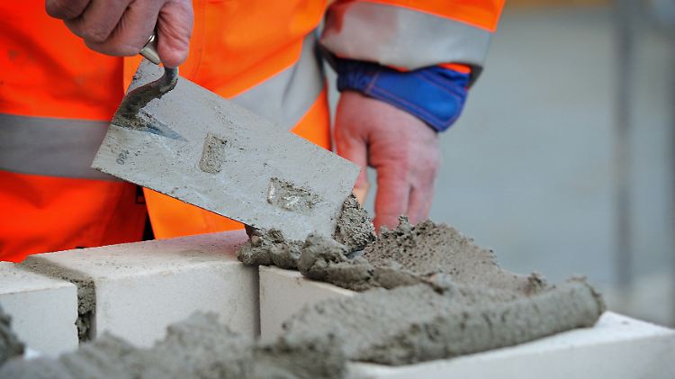 Das fachmännische Kratzen und der ruhige Strich sind unverkennbar: Hier ist ein Meister des Maurerhandwerks am Werk.