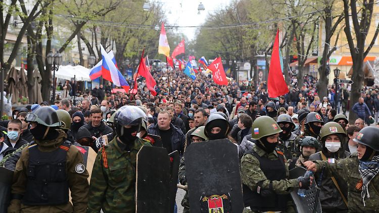 Pro-russische Demonstranten werden von ukrainischen Sicherheitskräften in Schach gehalten.