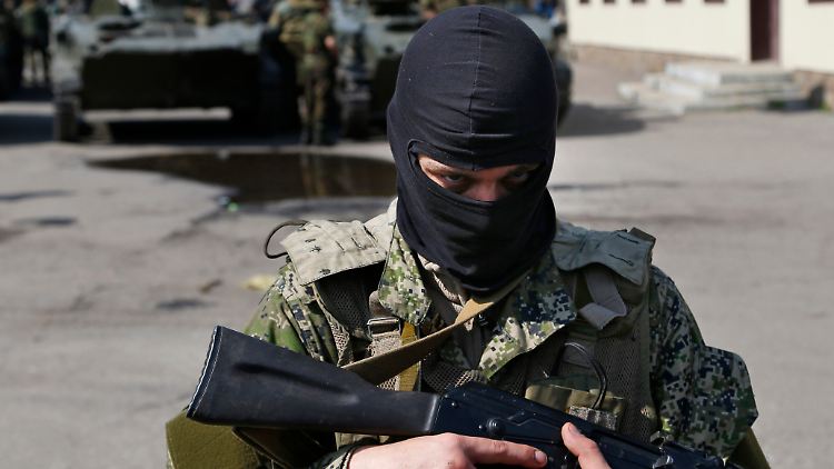 Ein Angehöriger einer wohl pro-russischen Gruppe bewacht in Slawjansk gepanzerte Fahrzeuge. 