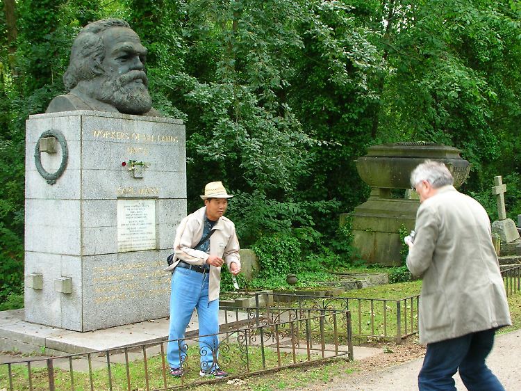 Darin gleichen sich die Reisenden: Touristen fotografieren sich vor dem Karl Marx-Denkmal auf dem Londoner Friedhof "Highgate".