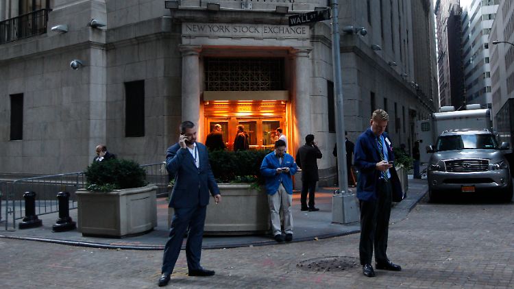 Die Zwischenberichte der Großbanken sind durch: Vor der New Yorl Stock Exchange finden gestresste Händler Zeit, mit dem eigenen Anlageberater zu telefonieren (Archivbild).