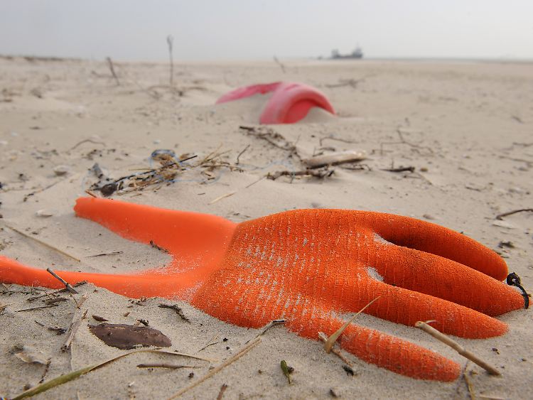 Angespülter Unrat: Arbeitshandschuh und Kunststoffkanister am Strand der Vogelschutzinsel Memmert (Niedersachsen).