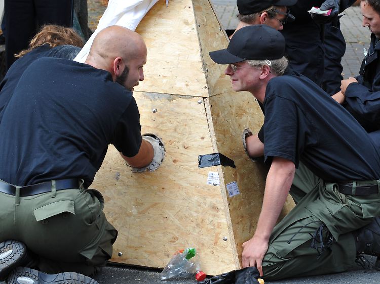 Gegendemonstranten haben sich auf der Strecke der Neonazis an eine Betonpyramide angekettet.