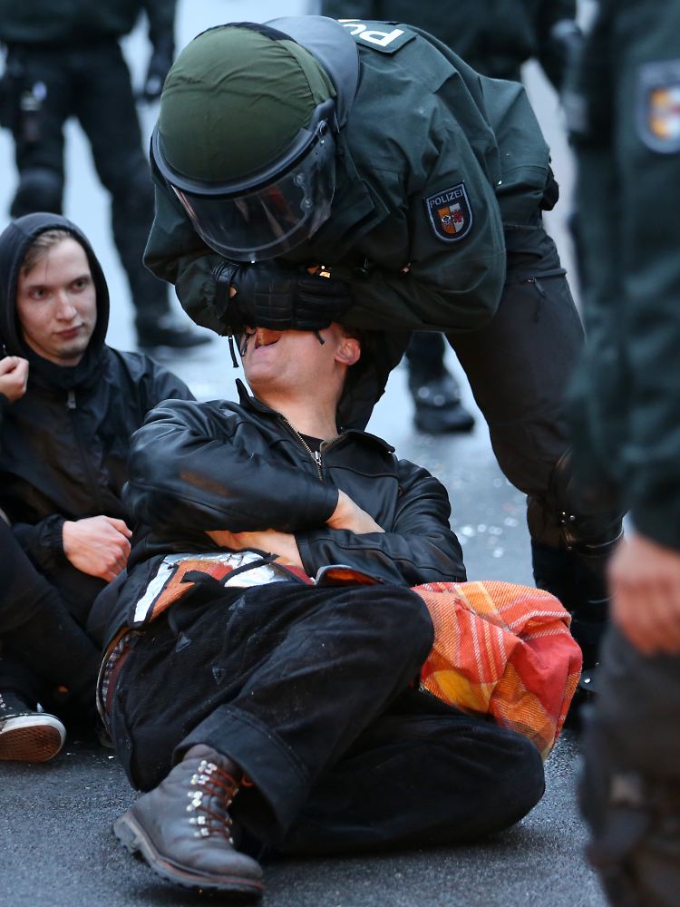 Die Polizei geht gegen eine Sitzblockade linker Gegendemonstranten vor.