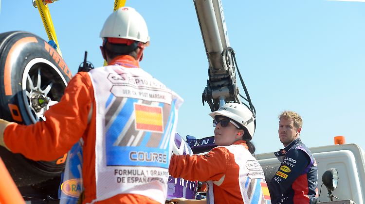 Mit versteinerter Miene lässt Sebastian Vettel sein Auto abschleppen.